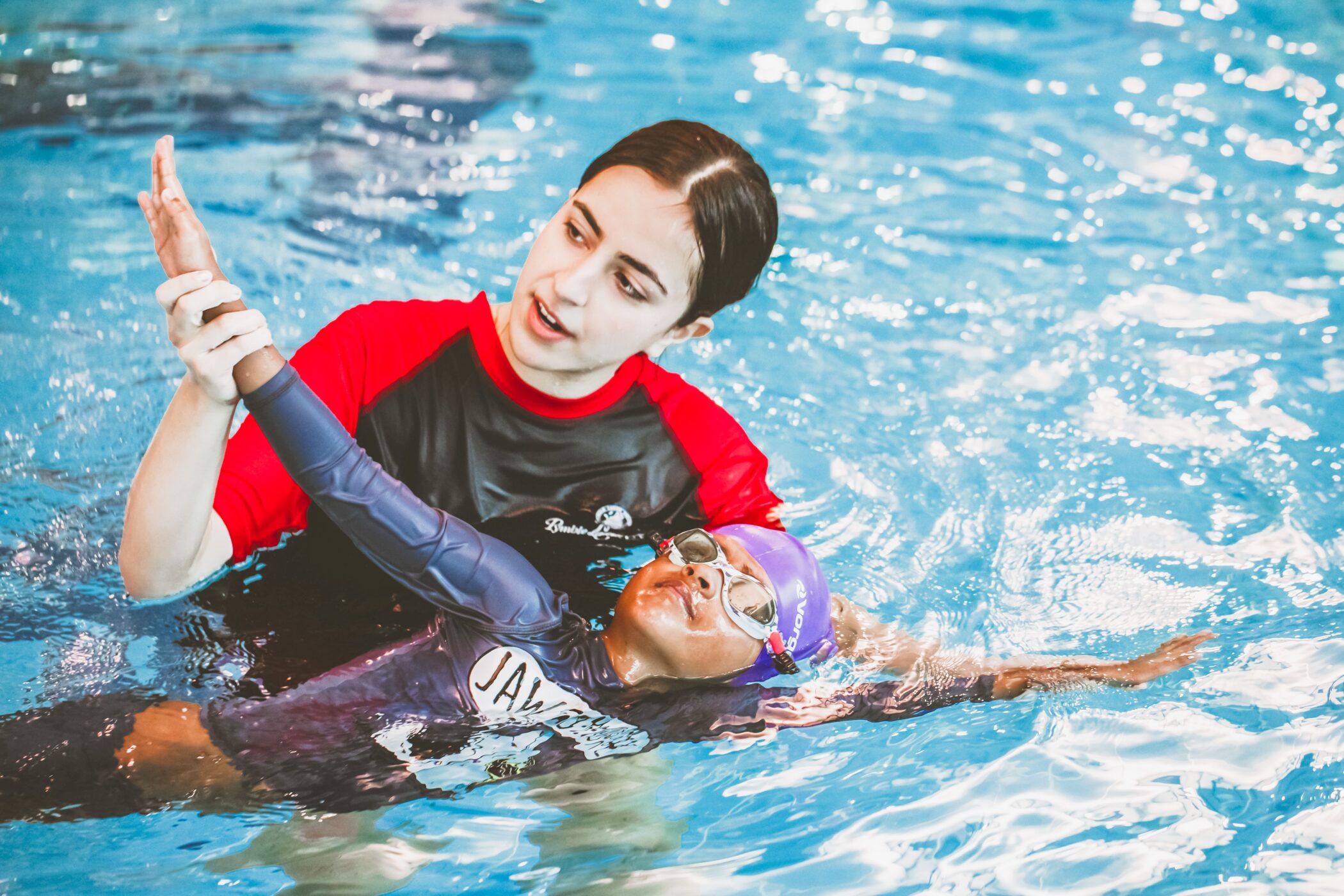 Pymble Swimming instructor guiding a child's arm position during backstroke practice