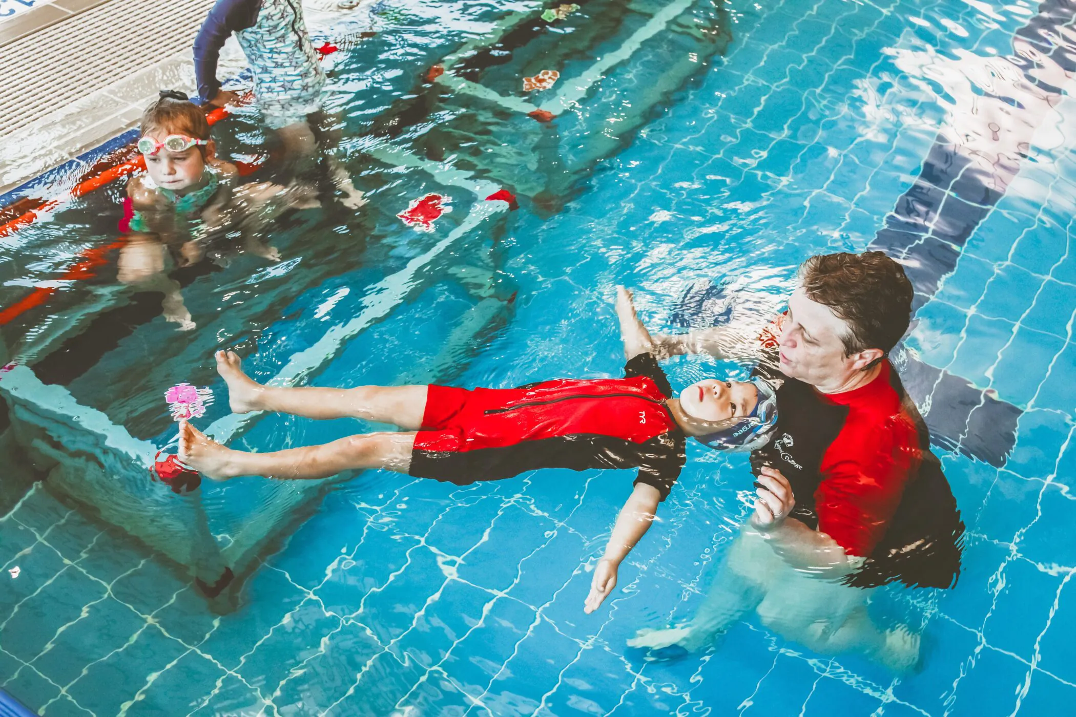 Pymble Swimming instructor guiding a child's arm position during backstroke practice