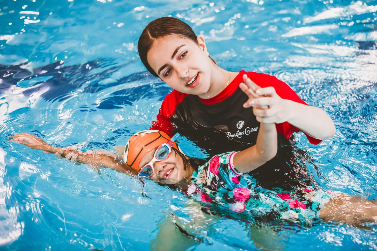 Pymble Swimming instructor guiding a young swimmer's backstroke technique