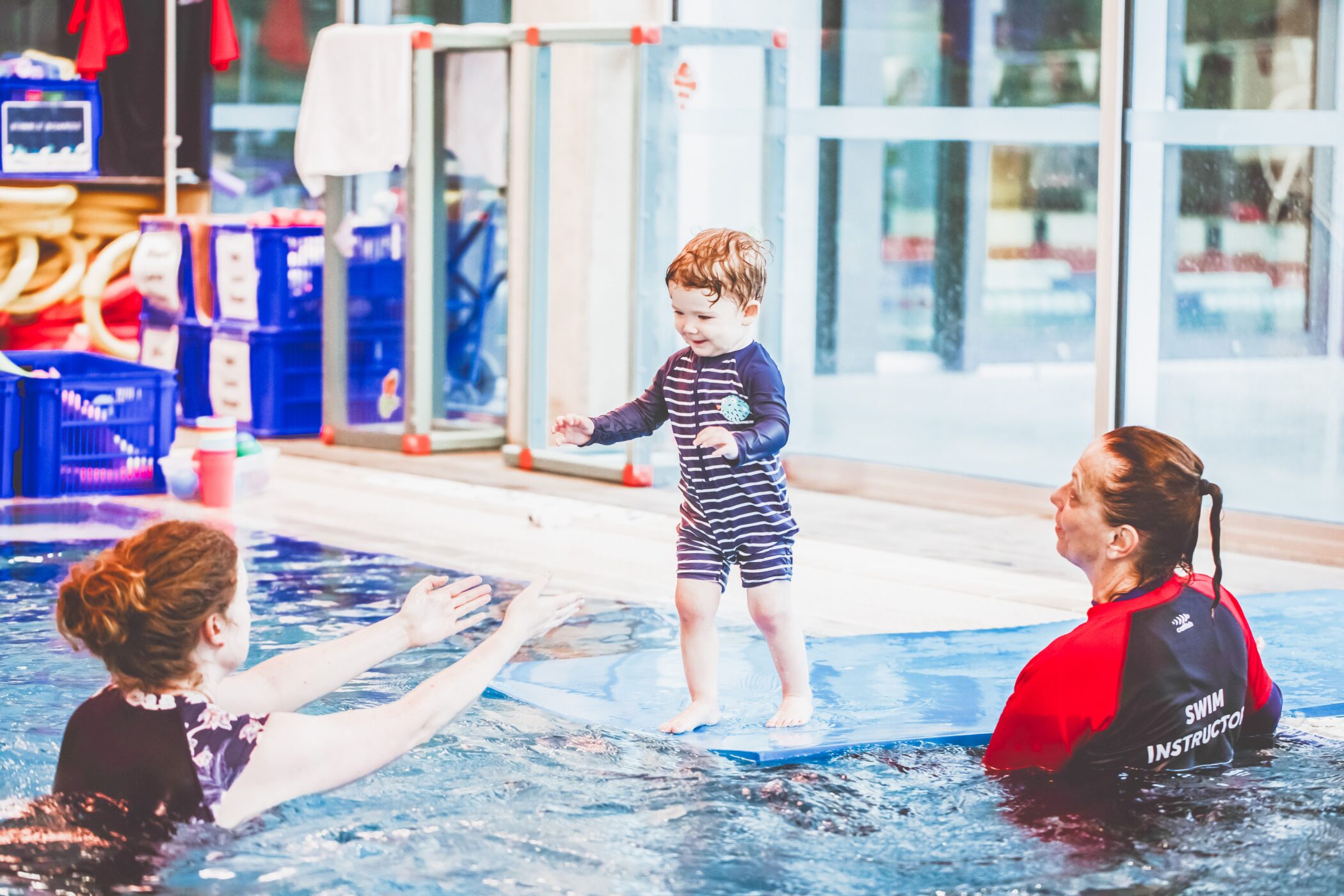 Toddler taking first steps towards the instructor during a Pymble Swimming lesson