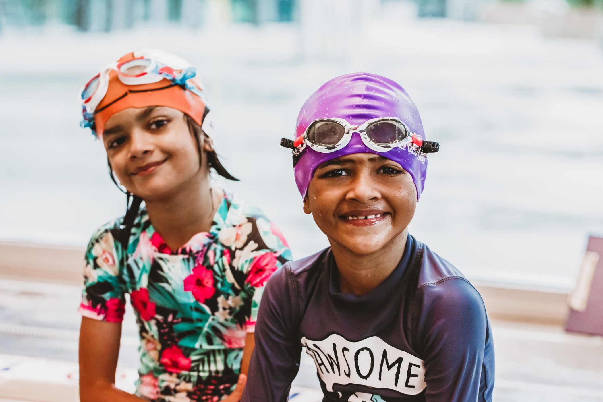 Two smiling children in swim caps and goggles at Pymble Swimming