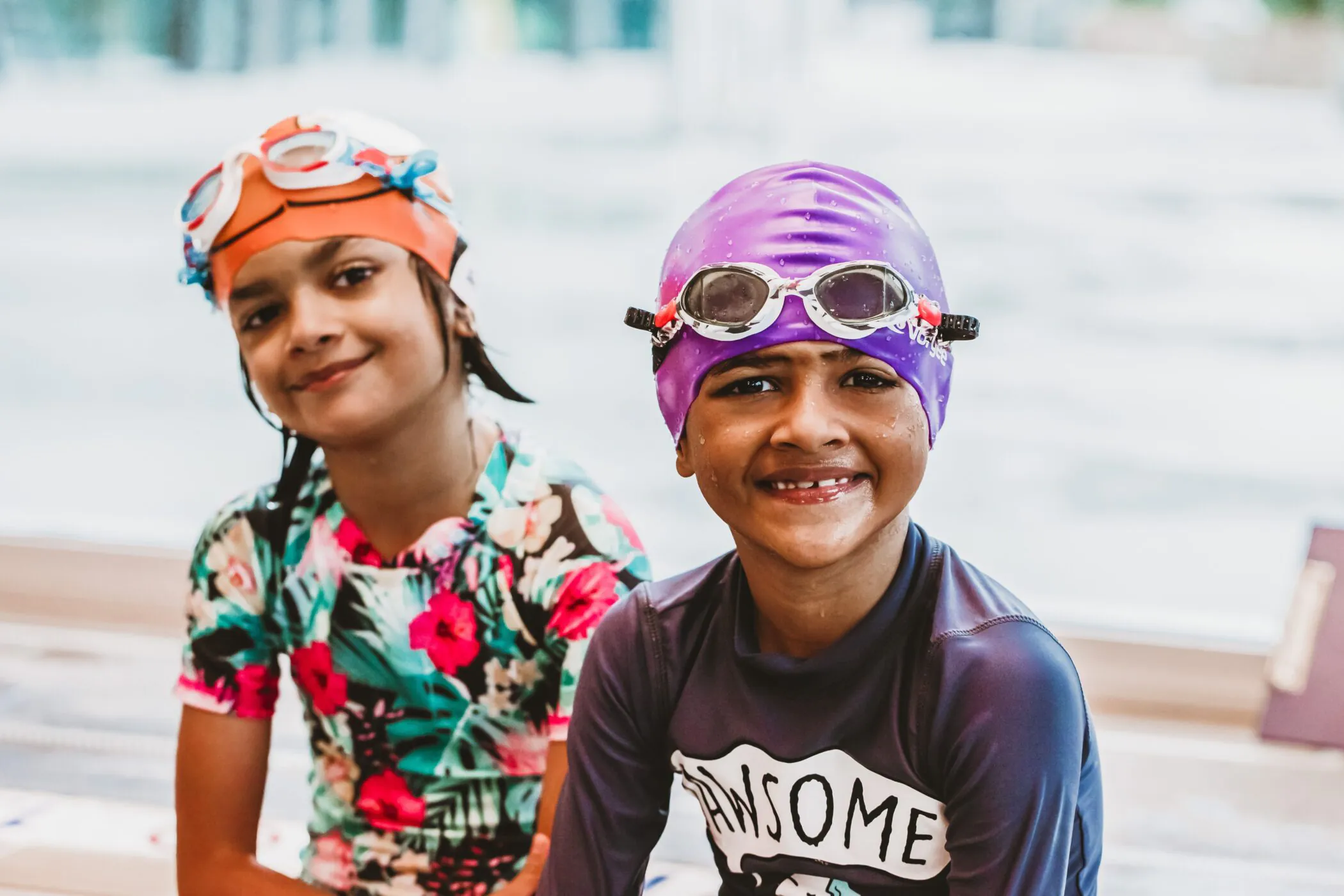 Two smiling children in swim caps and goggles at Pymble Swimming